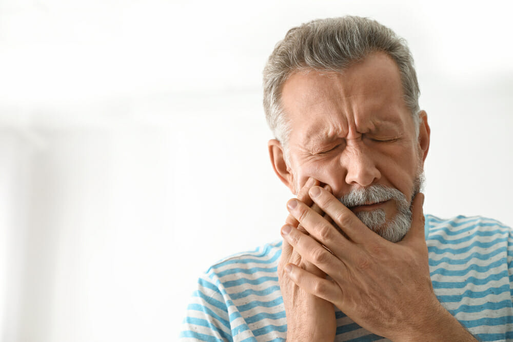 Elderly Man Holding Jaw in Pain